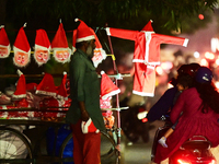 A motorist looks for Santa Claus costumes from a street vendor at a roadside in Hyderabad, India, on December 20, 2024, ahead of the Christm...