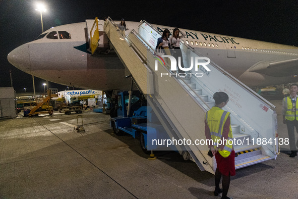 Passengers disembark on the tarmac from an Airbus A330 of Cathay Pacific flying from Hangzhou, China, in Hong Kong, China, on October 5, 202...