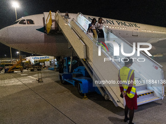 Passengers disembark on the tarmac from an Airbus A330 of Cathay Pacific flying from Hangzhou, China, in Hong Kong, China, on October 5, 202...