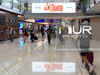 Passengers walk in the Hong Kong International Airport in Hong Kong, China, on November 3, 2024, as a publicity for the N? 5 of Chanel refle...