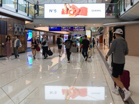 Passengers walk in the Hong Kong International Airport in Hong Kong, China, on November 3, 2024, as a publicity for the N? 5 of Chanel refle...