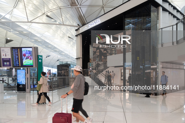 Passengers walk past the Chanel cube store at Hong Kong International Airport in Hong Kong, China, on November 3, 2024. 