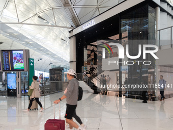 Passengers walk past the Chanel cube store at Hong Kong International Airport in Hong Kong, China, on November 3, 2024. (