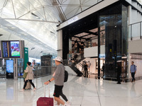 Passengers walk past the Chanel cube store at Hong Kong International Airport in Hong Kong, China, on November 3, 2024. (