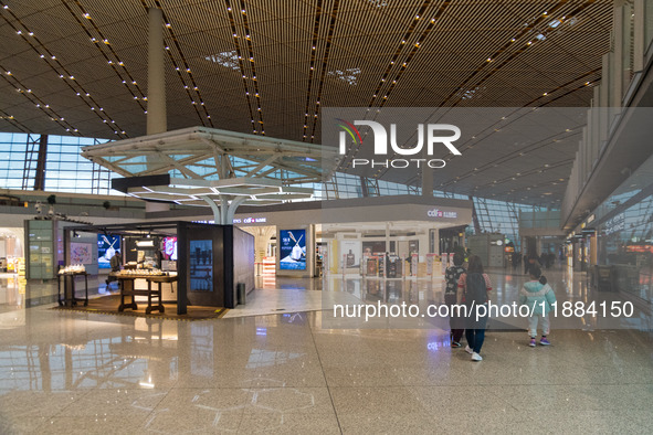 Passengers walk through a deserted Beijing Capital International Airport in Beijing, China, on December 1, 2024. 