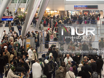 A general view of a crowd of travelers is seen at Duesseldorf Airport in Duesseldorf, Germany, on December 20, 2024, ahead of the Christmas...