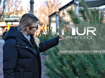 A woman looks at a Christmas tree in Odesa, Ukraine, on December 19, 2024. (