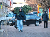 A man carries a Christmas tree in Odesa, Ukraine, on December 19, 2024. NO USE RUSSIA. NO USE BELARUS. (