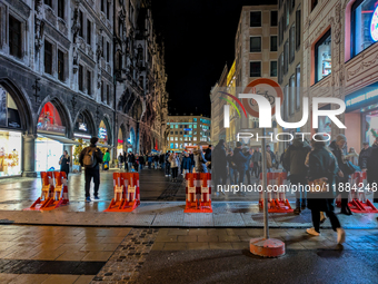 Pedestrians navigate through the safety barrier access point to the Christmas Market at Marienplatz in Munich, Bavaria, Germany, on December...