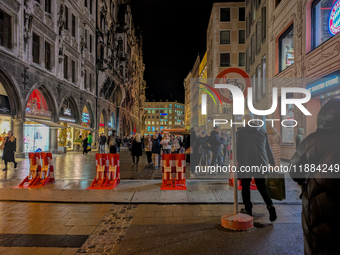 Pedestrians navigate through the safety barrier access point to the Christmas Market at Marienplatz in Munich, Bavaria, Germany, on December...