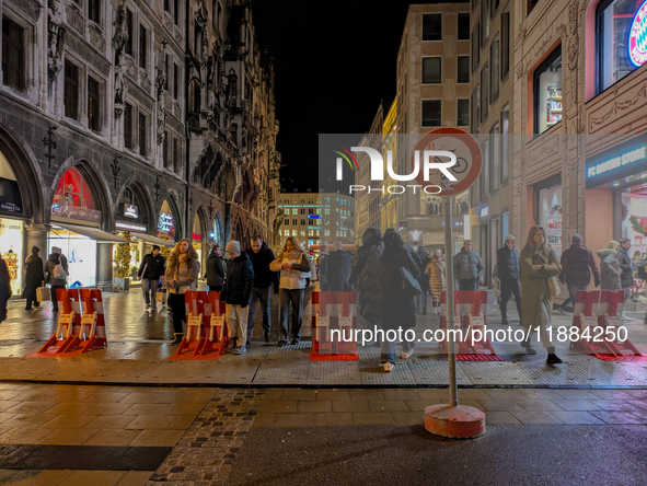 Pedestrians navigate through the safety barrier access point to the Christmas Market at Marienplatz in Munich, Bavaria, Germany, on December...