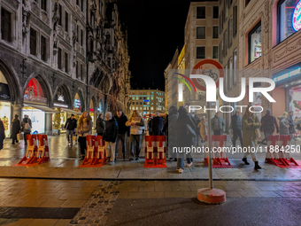 Pedestrians navigate through the safety barrier access point to the Christmas Market at Marienplatz in Munich, Bavaria, Germany, on December...