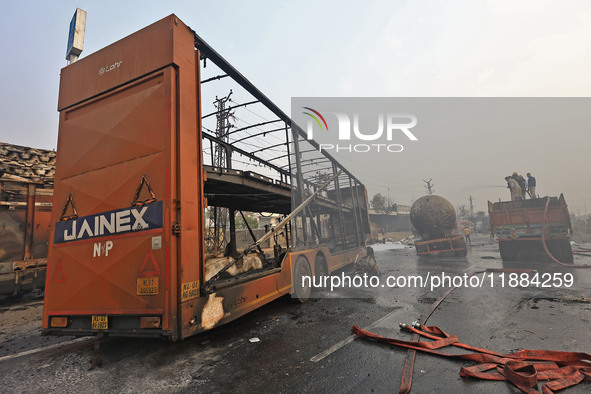 Firefighters douse the fire at the site of the accident after a tanker loaded with LPG collides with other vehicles and catches fire on the...