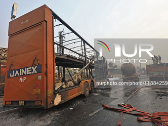 Firefighters douse the fire at the site of the accident after a tanker loaded with LPG collides with other vehicles and catches fire on the...