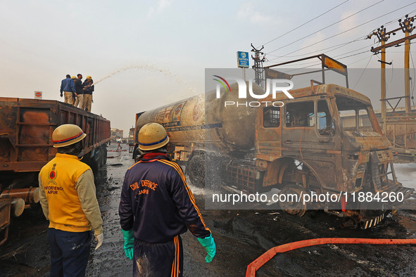 Firefighters douse the fire at the site of the accident after a tanker loaded with LPG collides with other vehicles and catches fire on the...