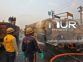 Firefighters douse the fire at the site of the accident after a tanker loaded with LPG collides with other vehicles and catches fire on the...