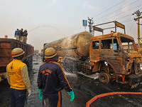 Firefighters douse the fire at the site of the accident after a tanker loaded with LPG collides with other vehicles and catches fire on the...