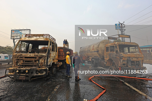 Firefighters douse the fire at the site of the accident after a tanker loaded with LPG collides with other vehicles and catches fire on the...