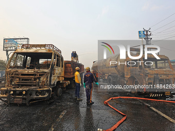 Firefighters douse the fire at the site of the accident after a tanker loaded with LPG collides with other vehicles and catches fire on the...