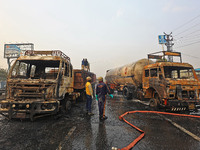 Firefighters douse the fire at the site of the accident after a tanker loaded with LPG collides with other vehicles and catches fire on the...