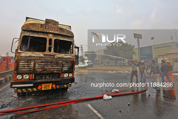 Firefighters douse the fire at the site of the accident after a tanker loaded with LPG collides with other vehicles and catches fire on the...