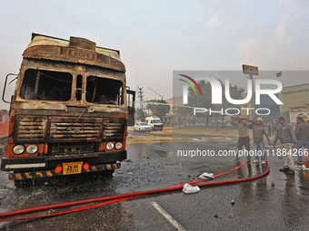 Firefighters douse the fire at the site of the accident after a tanker loaded with LPG collides with other vehicles and catches fire on the...