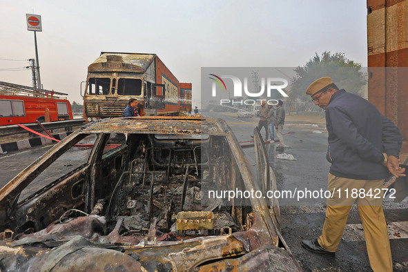 Firefighters douse the fire at the site of the accident after a tanker loaded with LPG collides with other vehicles and catches fire on the...