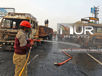 Firefighters douse the fire at the site of the accident after a tanker loaded with LPG collides with other vehicles and catches fire on the...