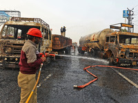 Firefighters douse the fire at the site of the accident after a tanker loaded with LPG collides with other vehicles and catches fire on the...