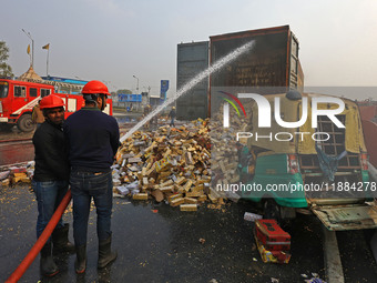 Firefighters douse the fire at the site of the accident after a tanker loaded with LPG collides with other vehicles and catches fire on the...