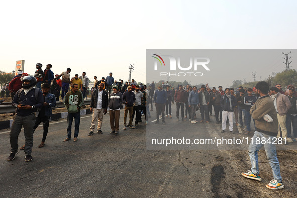 Local residents gather at the site of the accident after a tanker loaded with LPG collides with other vehicles and catches fire on the Jaipu...