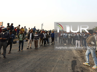 Local residents gather at the site of the accident after a tanker loaded with LPG collides with other vehicles and catches fire on the Jaipu...