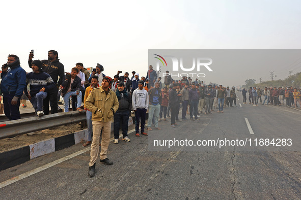 Local residents gather at the site of the accident after a tanker loaded with LPG collides with other vehicles and catches fire on the Jaipu...