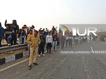 Local residents gather at the site of the accident after a tanker loaded with LPG collides with other vehicles and catches fire on the Jaipu...