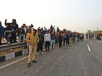 Local residents gather at the site of the accident after a tanker loaded with LPG collides with other vehicles and catches fire on the Jaipu...