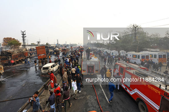 Firefighters douse the fire at the site of the accident after a tanker loaded with LPG collides with other vehicles and catches fire on the...