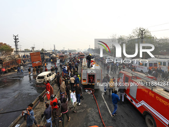 Firefighters douse the fire at the site of the accident after a tanker loaded with LPG collides with other vehicles and catches fire on the...