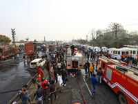 Firefighters douse the fire at the site of the accident after a tanker loaded with LPG collides with other vehicles and catches fire on the...