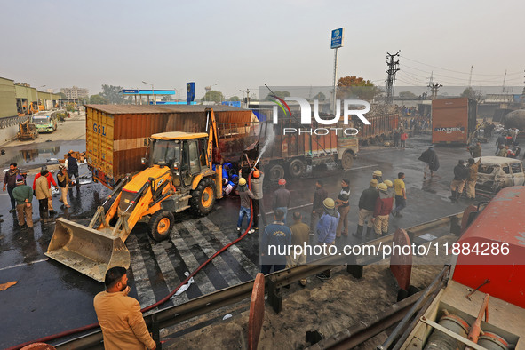 Firefighters douse the fire at the site of the accident after a tanker loaded with LPG collides with other vehicles and catches fire on the...