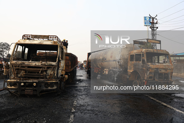 Firefighters douse the fire at the site of the accident after a tanker loaded with LPG collides with other vehicles and catches fire on the...