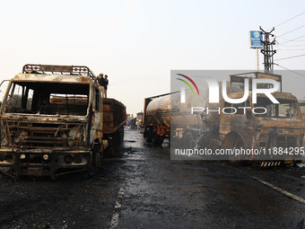 Firefighters douse the fire at the site of the accident after a tanker loaded with LPG collides with other vehicles and catches fire on the...