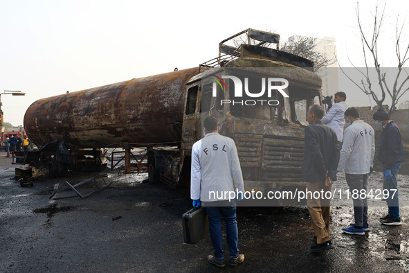 FSL team members inspect the site of the accident after a tanker loaded with LPG collides with some other vehicles and catches fire on the J...