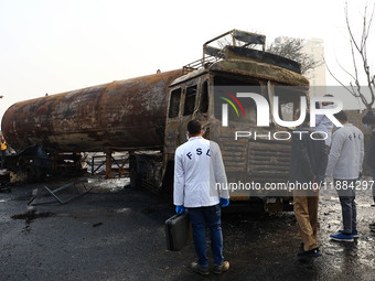 FSL team members inspect the site of the accident after a tanker loaded with LPG collides with some other vehicles and catches fire on the J...