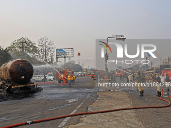 Firefighters douse the fire at the site of the accident after a tanker loaded with LPG collides with other vehicles and catches fire on the...