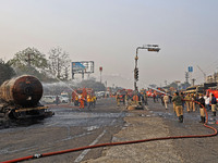 Firefighters douse the fire at the site of the accident after a tanker loaded with LPG collides with other vehicles and catches fire on the...