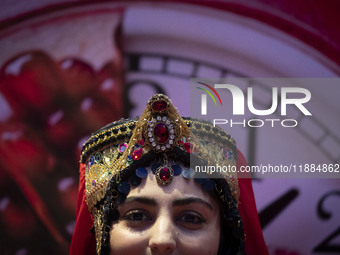 A young Iranian woman wearing a traditional hat poses for a photograph after performing in Yalda Night celebrations at the Iran Mall shoppin...