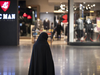 A veiled Iranian woman stands at the Iran Mall shopping mall in northwestern Tehran, Iran, on December 20, 2024, during Yalda Night celebrat...