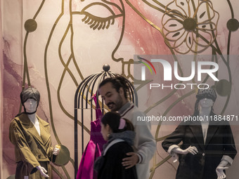 An Iranian couple walks past mannequins decorated in a shop window during Yalda Night celebrations at the Iran Mall shopping mall in northwe...