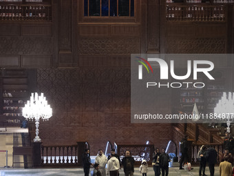 Iranian people walk under portraits of Iran's Supreme Leader, Ayatollah Ali Khamenei, and Iran's Late Leader, Ayatollah Ruhollah Khomeini, w...