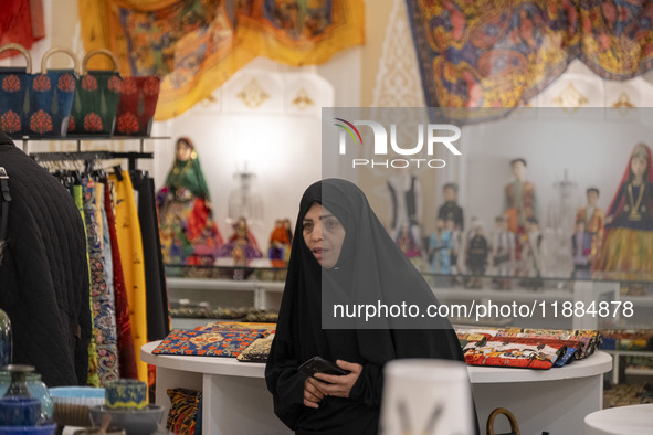 A veiled Iranian woman looks on while visiting the Iran Mall shopping mall in northwestern Tehran, Iran, on December 20, 2024, during Yalda...